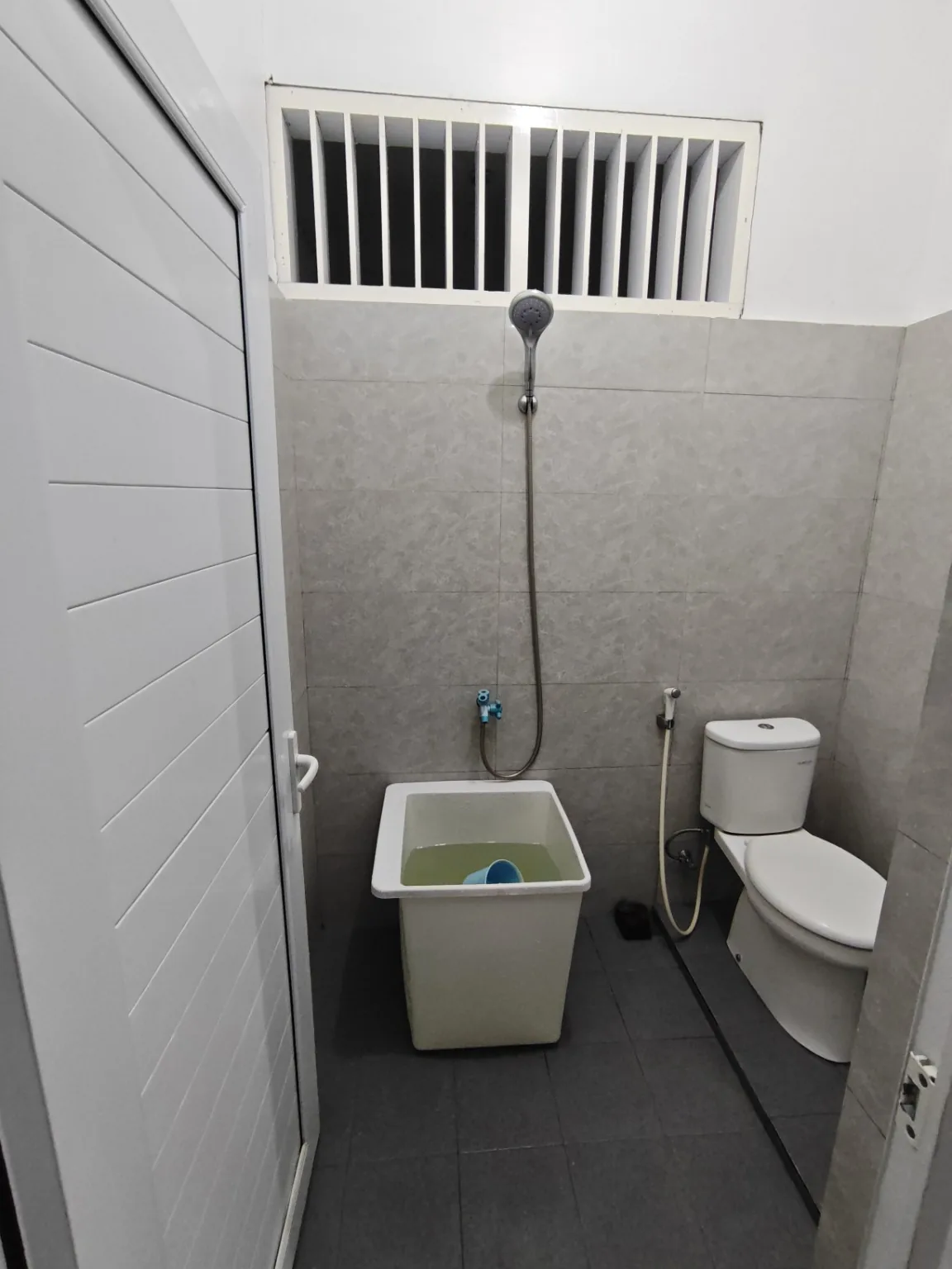 Kamar mandi dengan shower dan toilet duduk