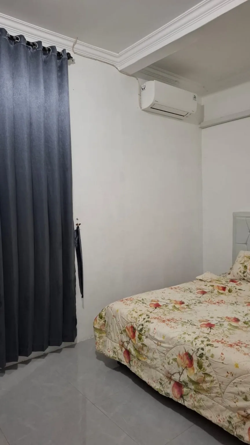 Kamar utama dengan tempat tidur, gorden, dan AC